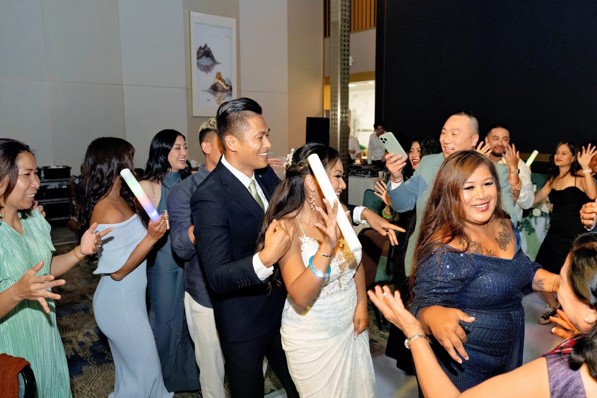 Wedding guests arms up singing along on a packed dance floor